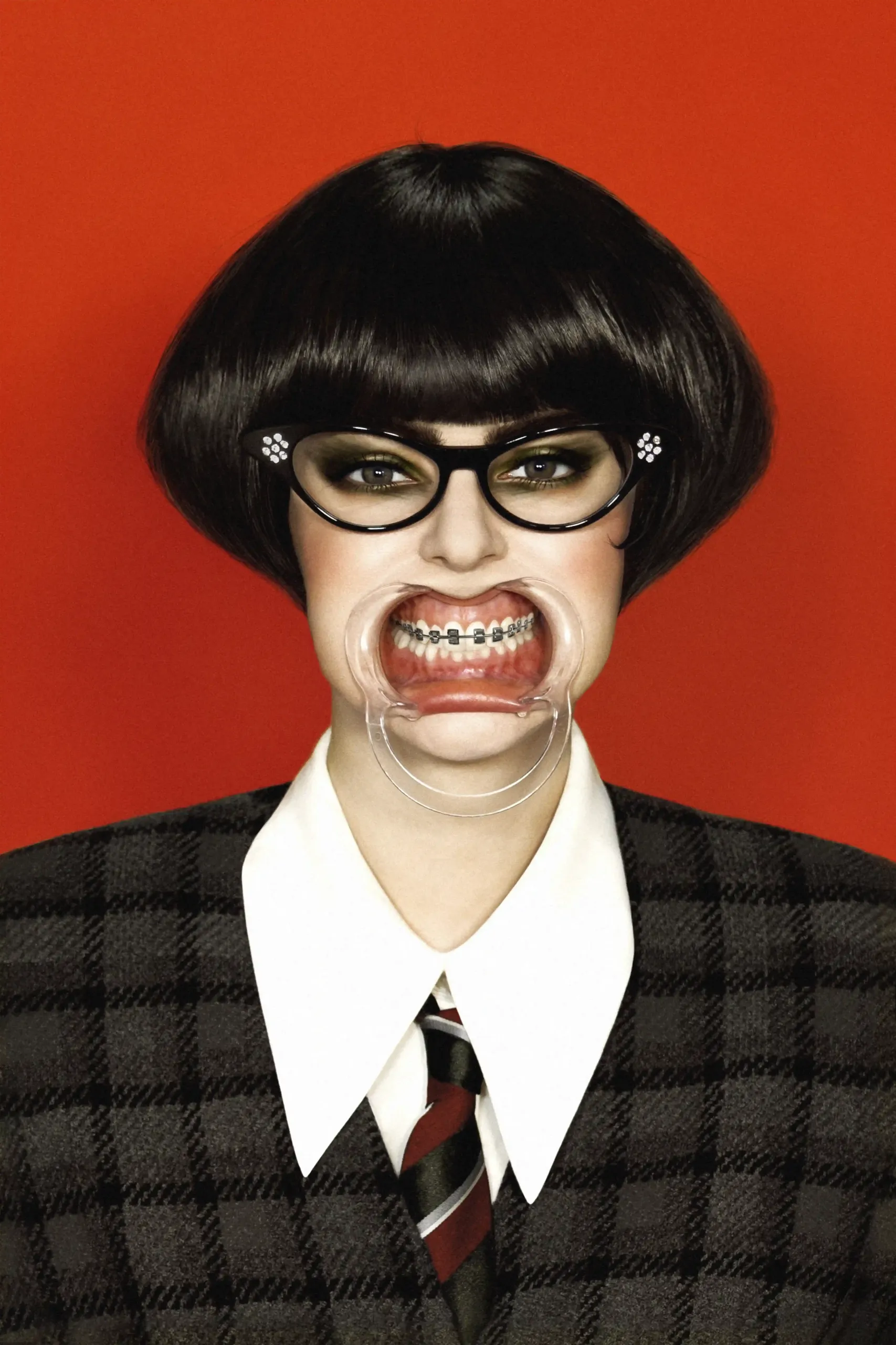 portrait of a girl wearing a bracelet. She seems angry. The background is vivid red, she wears a black school uniform.